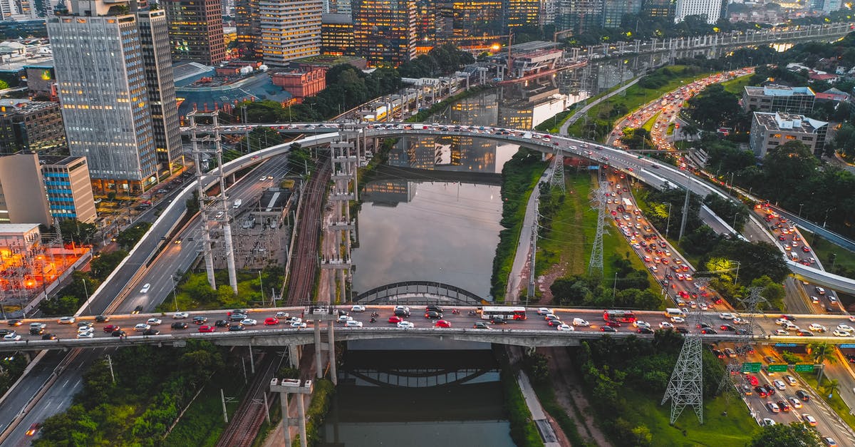 What does amber - green traffic light mean in South Korea? - Drone view of large intersection with automobiles in busy city with contemporary skyscrapers and green lawns