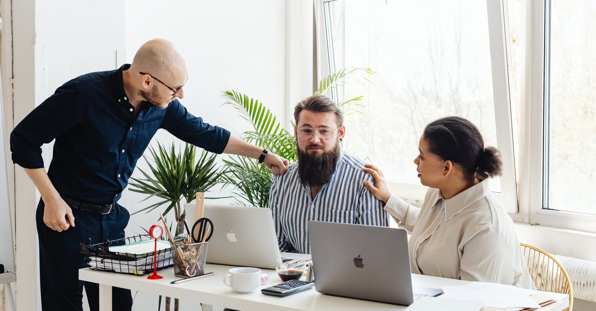 What does the acronym "ECO" mean in discussions of visas? - Man in Blue Long Sleeve Shirt Sitting Beside Woman in White Long Sleeve Shirt Using Macbook