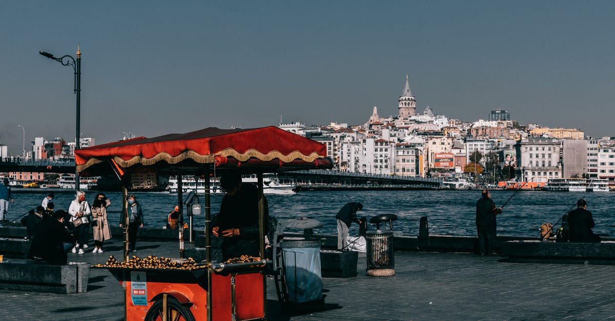 What food is Chicago (USA) famous for? - Red food truck located on crowded quay near sea against coastal city with buildings and Galata tower in Istanbul in Turkey