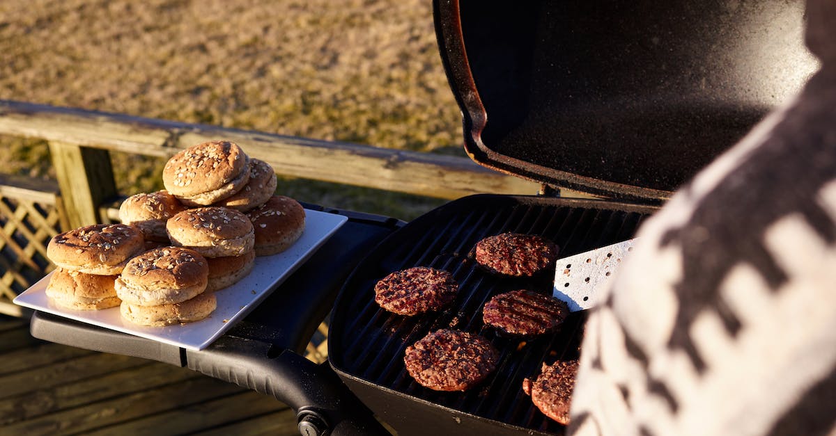 What food to take on a 3-4 day long hiking trip? - Crop woman grilling meat for burgers outdoors