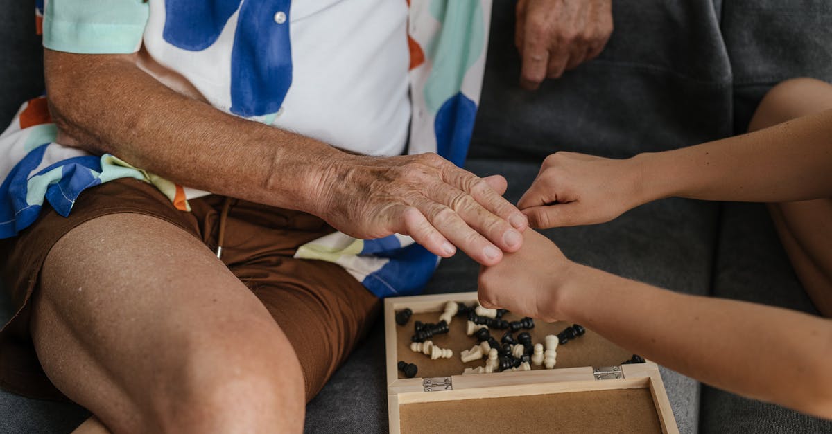 What game did I see in Verona, Italy? - Person in Blue Shirt and White Pants Holding Black and White Chess Piece