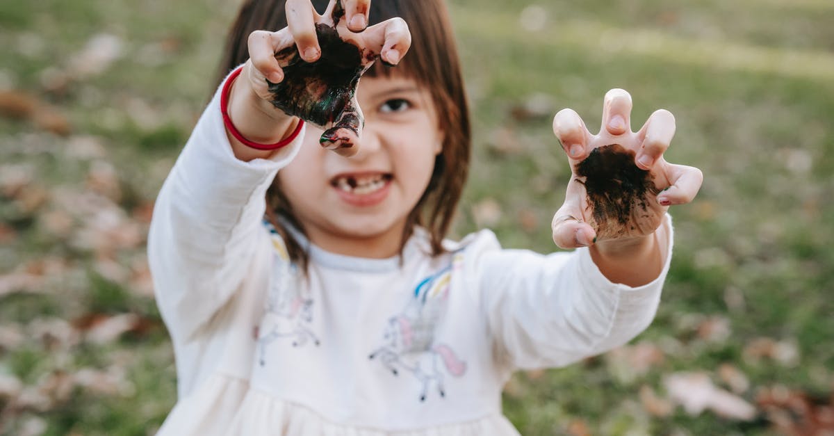 What gesture to make when hitchhiking in Iran? - Funny girl with painted hands making scary face while playing in park during Halloween celebration