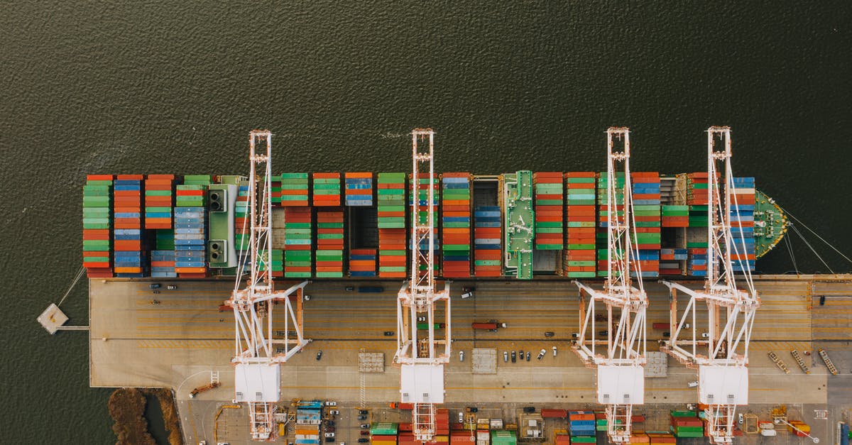 What happened to lifting the liquids ban? - Colorful cargo containers on ship near pier