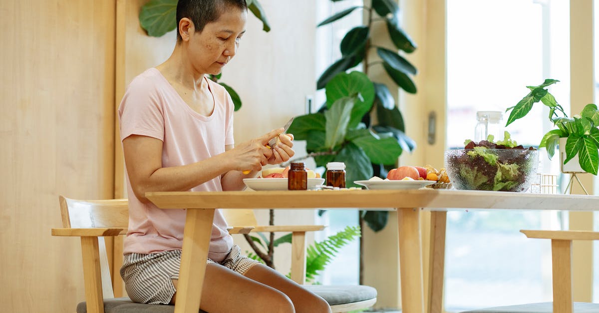 What happens if you become seriously ill during a flight? - Tranquil middle aged ethnic lady cutting fruits during illness at home