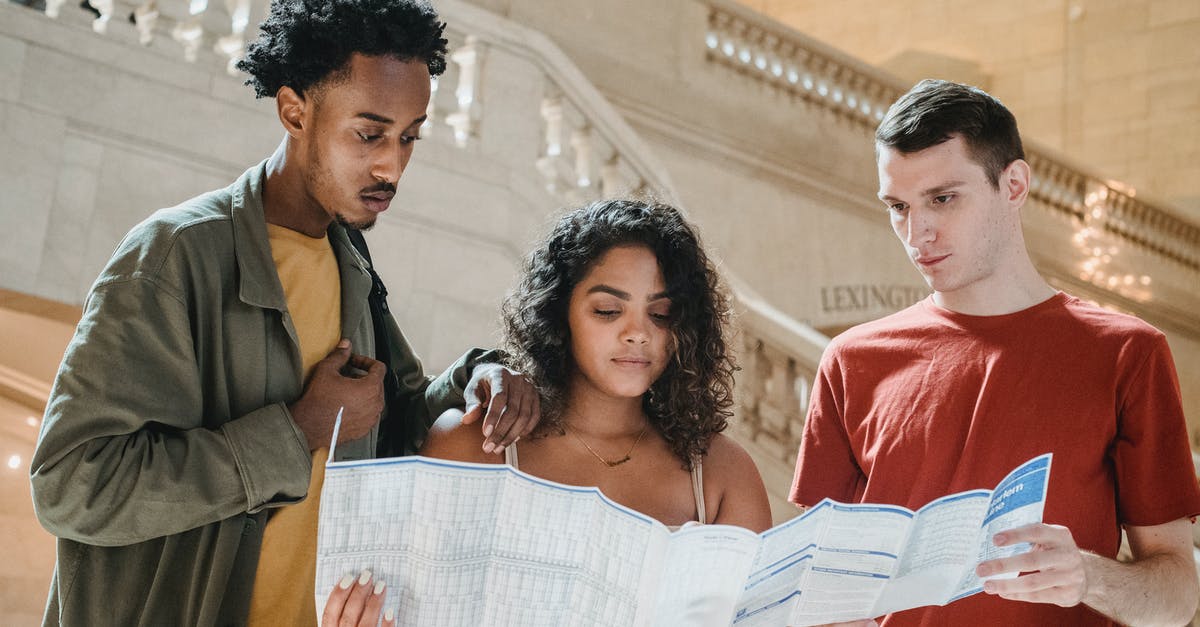 What happens on the immigration gate if a passenger lost their fingerprints? - Serious young diverse millennials reading map in railway station terminal