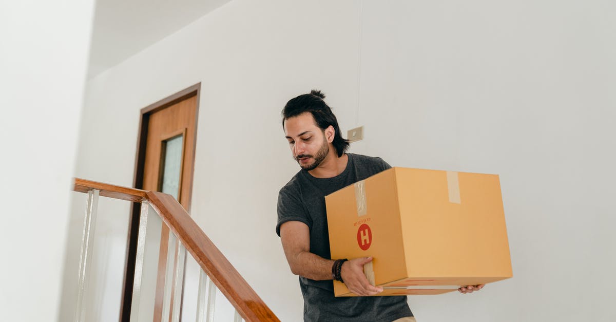 What happens to items removed from luggage? - Adult man carrying box down stairs