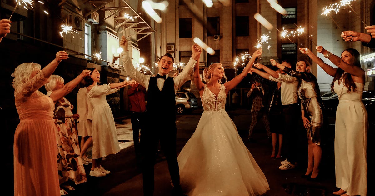 What I need to know when going to typical (traditional) wedding ceremony in Philippines? - Cheerful young bride and groom with guests dancing on street with sparklers in hands during wedding party