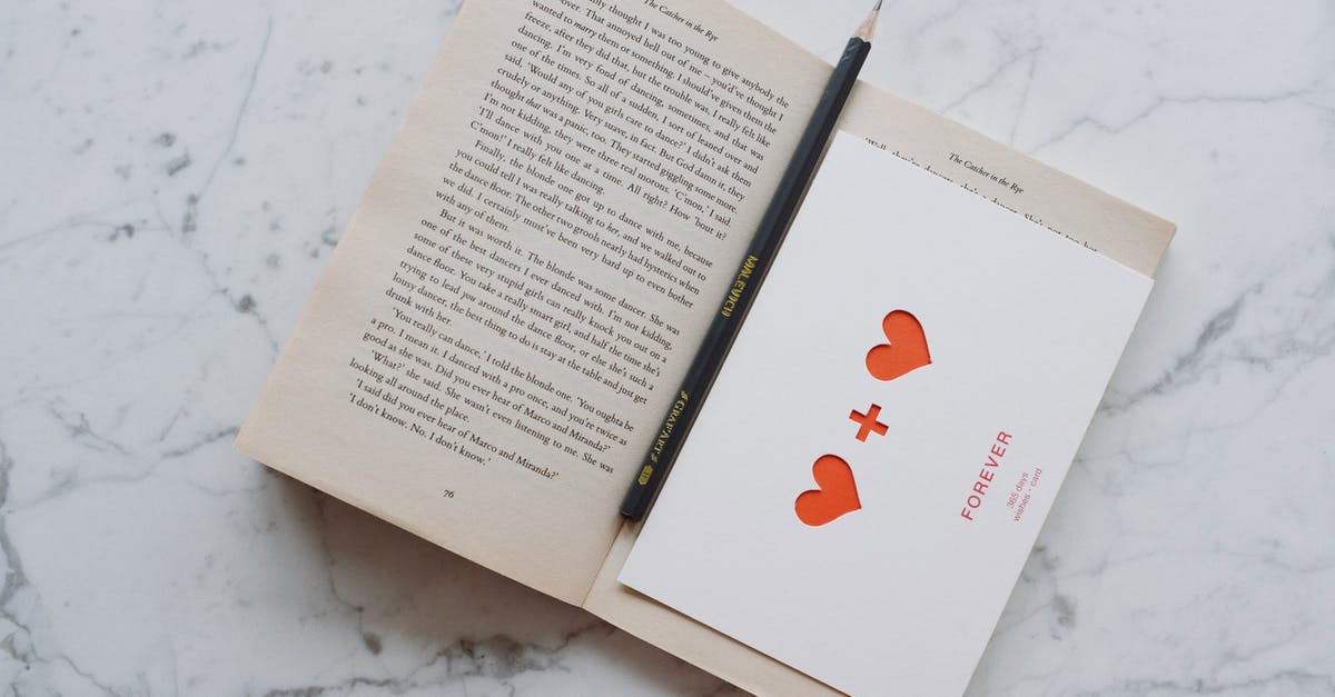 What is a "Partially open bathroom"? - Top view of opened novel book with pencil and romantic postcard placed on white marble surface