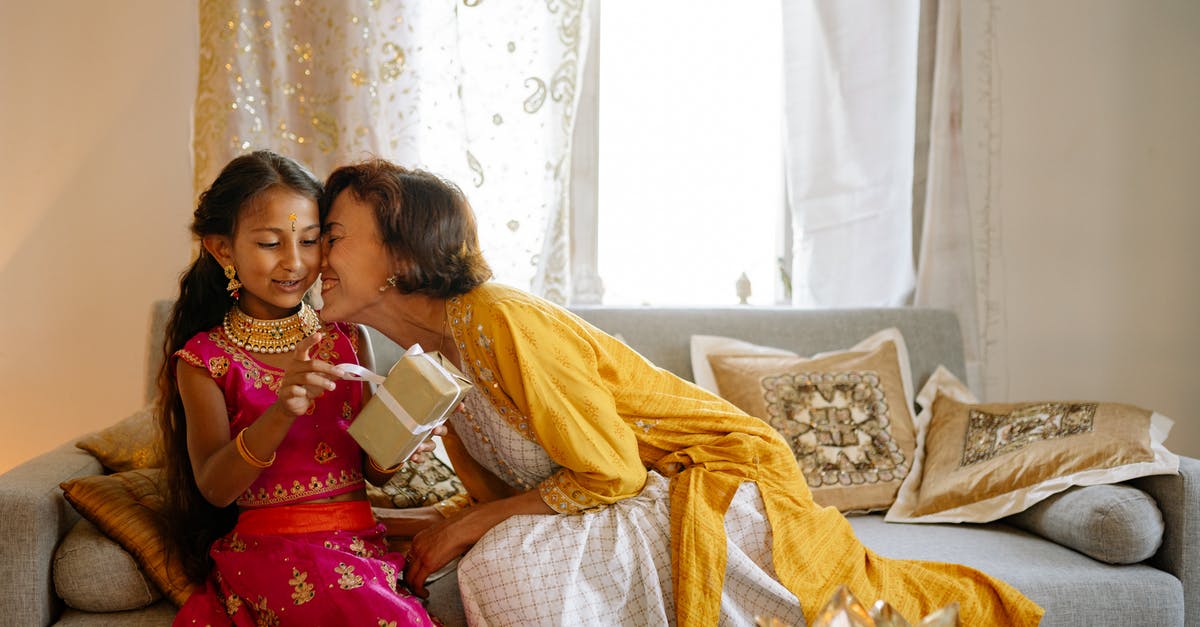 What is an appropriate gift for an Indian wedding? - Woman Kissing the Girl While Sitting on Sofa