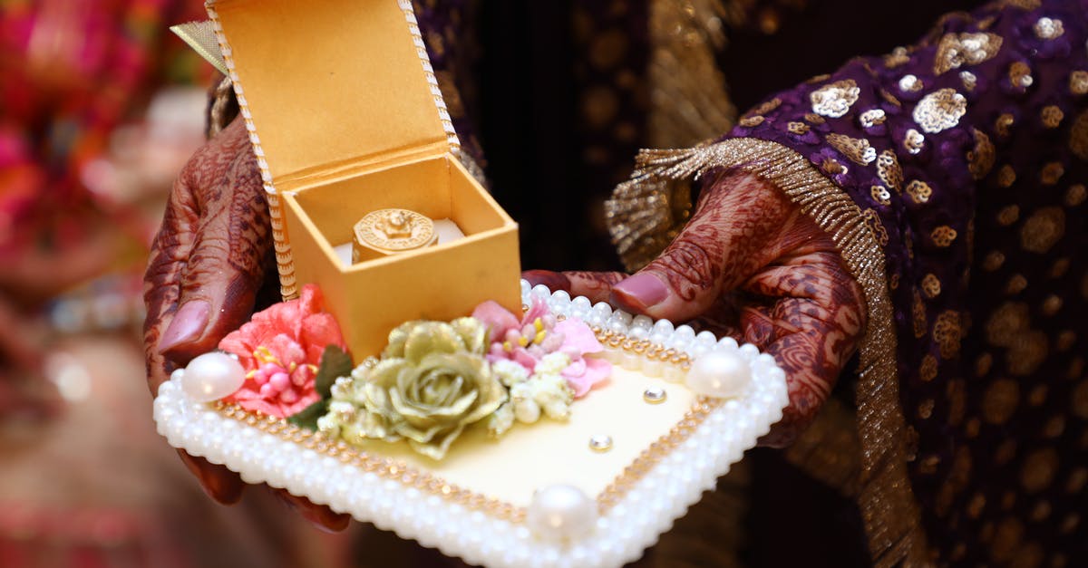 What is an appropriate gift for an Indian wedding? - Crop ethnic woman showing traditional present