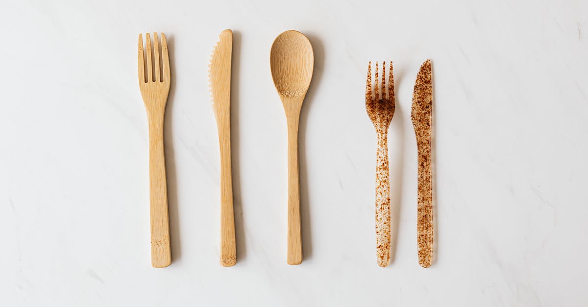 What is an easy alternative to flying to Athens from London? - Top view of wooden and plastic cutlery placed in row on white marble table