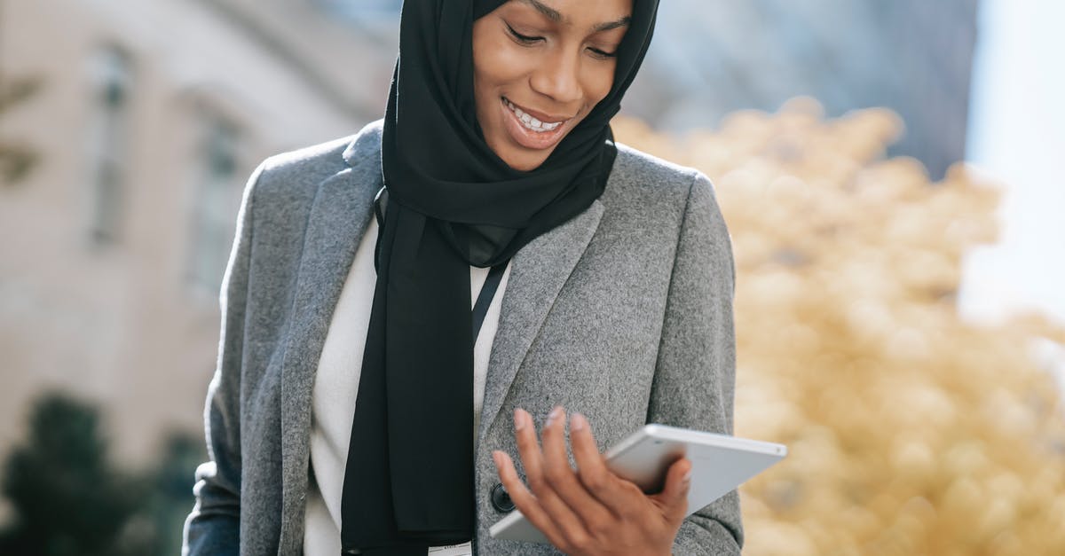 What is appropriate attire for women in Muslim countries? - Black woman in hijab browsing tablet