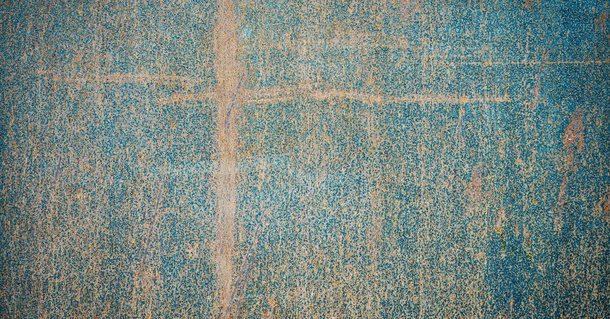 What is more effective seeking luggage damage compensation from the aiport or airline? - Top view of painted weathered surface with damaged patterns and scratches as abstract background