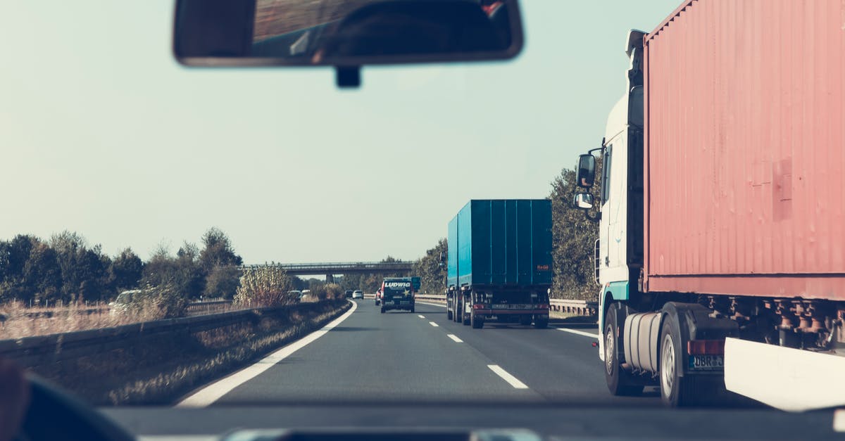 What is the cheapest and fastest way of traveling between Liege and Paris with deterministic travelling times? - Blue and Red Freight Truck on Road