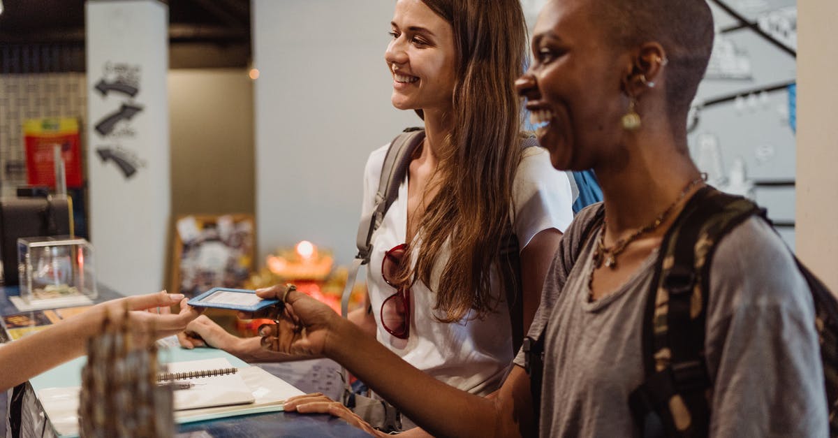 What is the cheapest hostel in the world? - Women Receiving a Hotel Room Card at the Reception Desk 