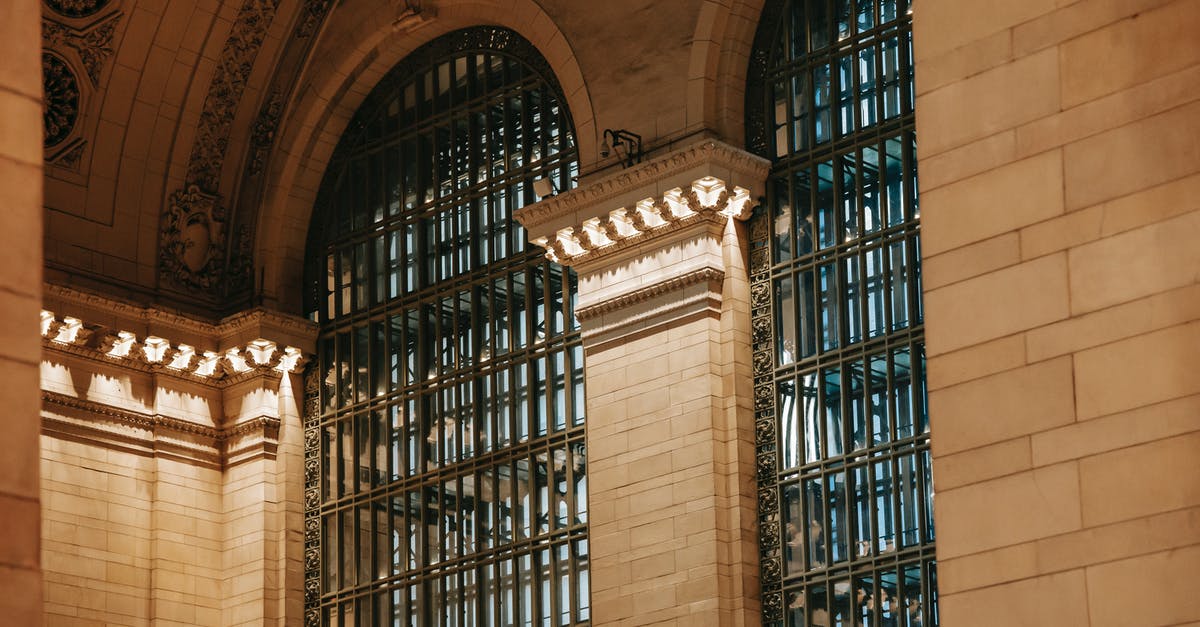 What is the cheapest travel destination in Central/South America (from Chicago)? - From below of illuminated interior of Grand Central Terminal station with high decorated ceiling and big windows with pillars in New York USA