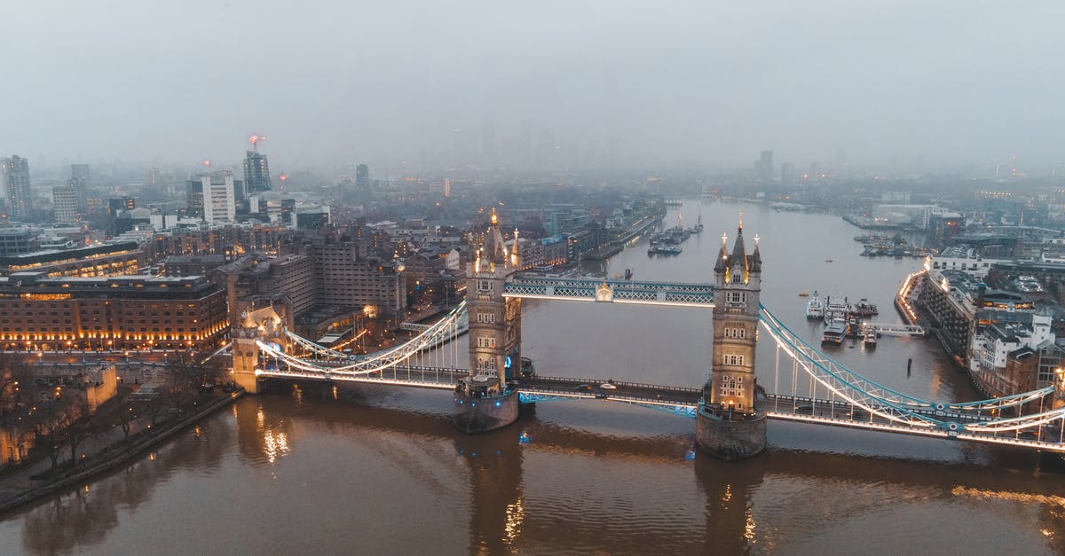 What is the closest free street parking to London city center? - Drone view of London city located in England with illuminated Tower Bridge on River Thames near buildings in misty weather under gray cloudy sky in daylight