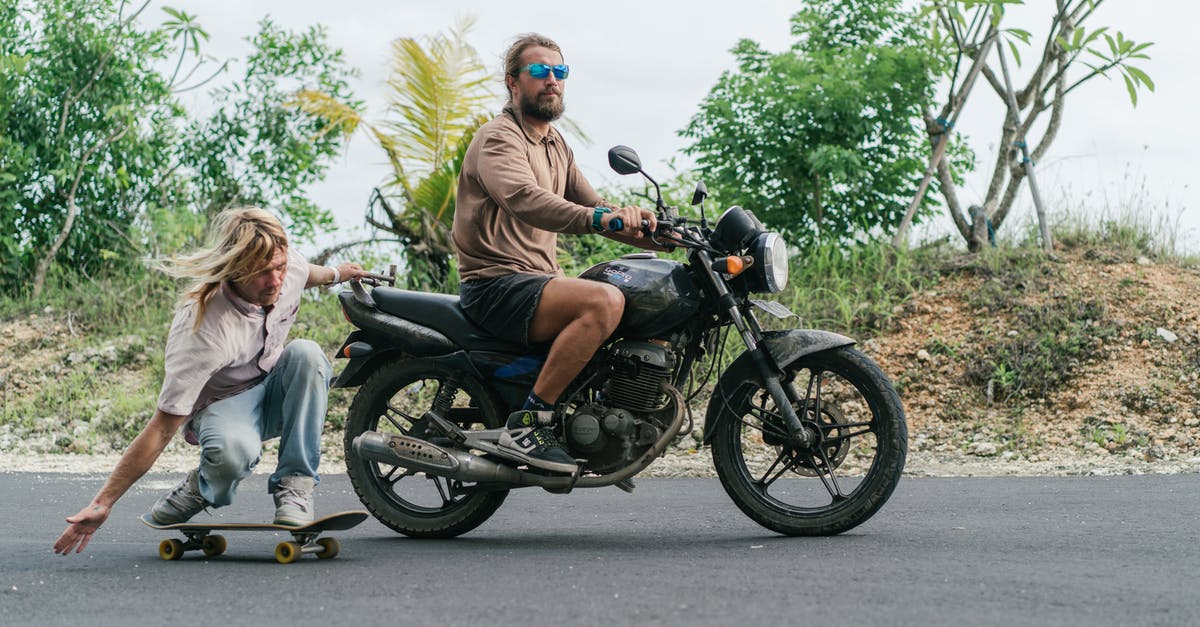 What is the experience of driving in Thailand? [closed] - Man on motorcycle riding skater holding back of motorcycle