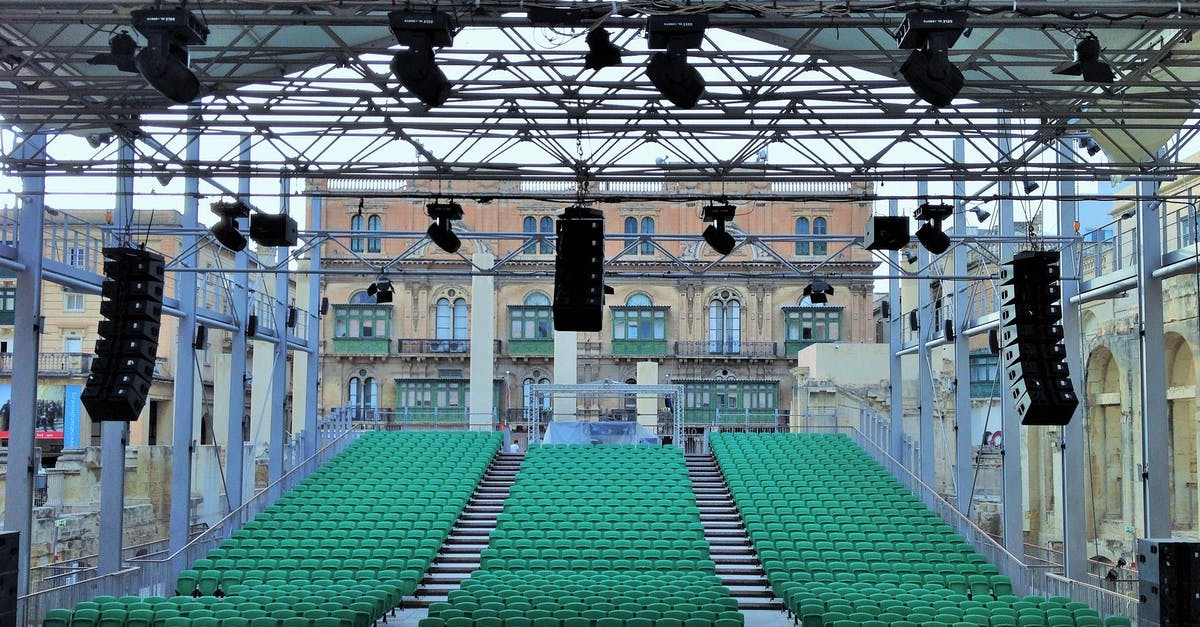 What is the location of this performance? - Outdoor auditorium and stage with professional equipment on city square