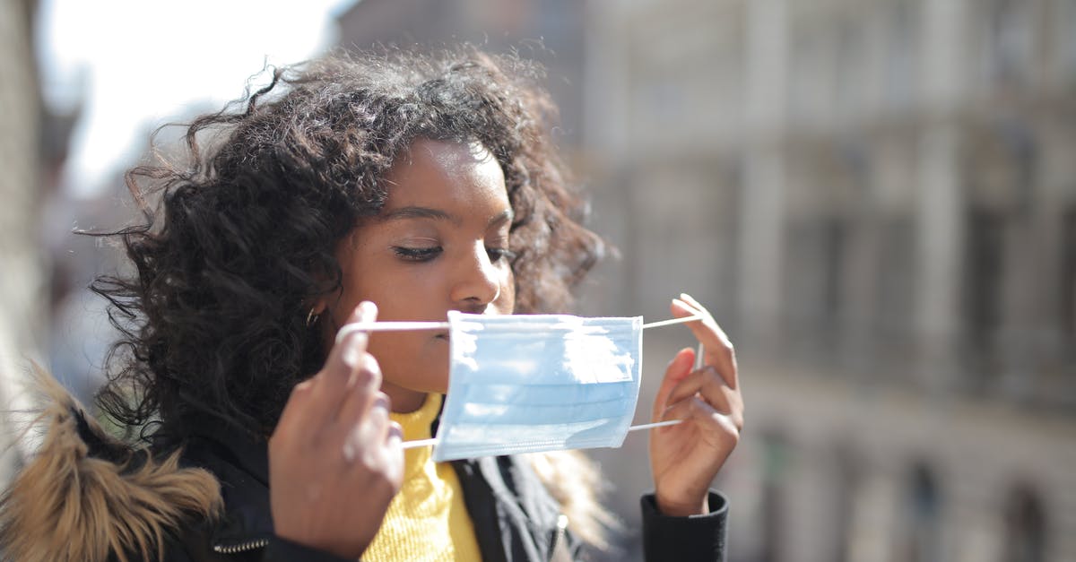 What is the most isolated building in the world? - Serious young ethnic lady putting on medical mask on street