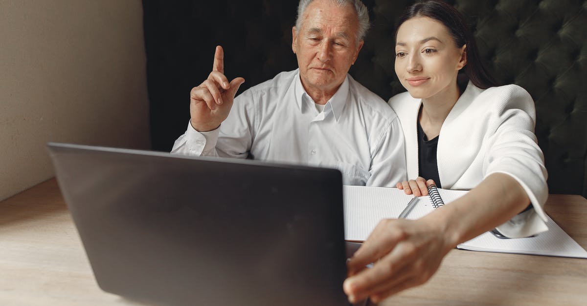 What is the point of checking in online? [duplicate] - Positive colleagues of different aged using laptop in modern workspace