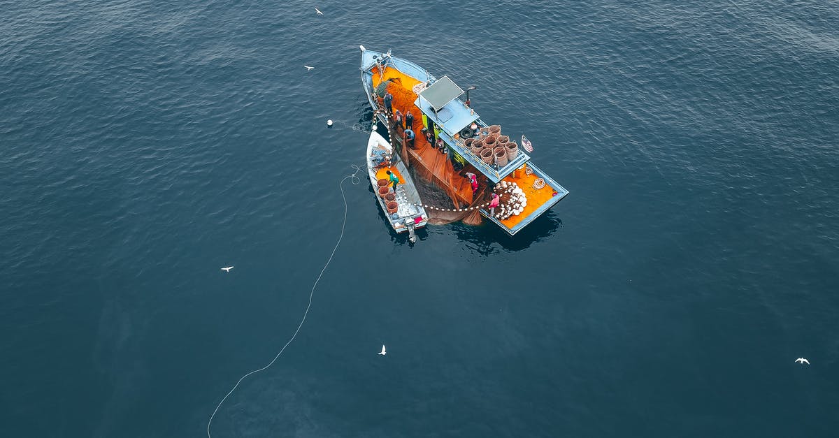 What is the process for getting on a flight in India, starting from entry to the airport? - Drone view of boat and vessel moored on rippling sea water during traditional net fishing