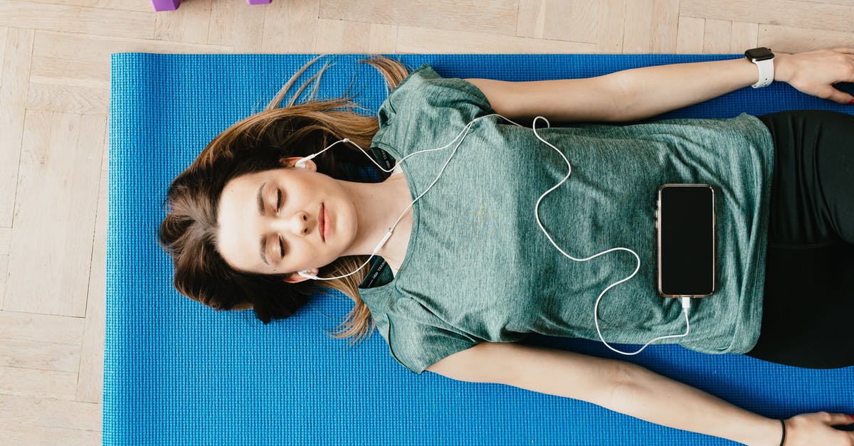 What is the use of a blue UN Laissez-Passer? - Peaceful woman in earphones resting in Shavasana pose at home