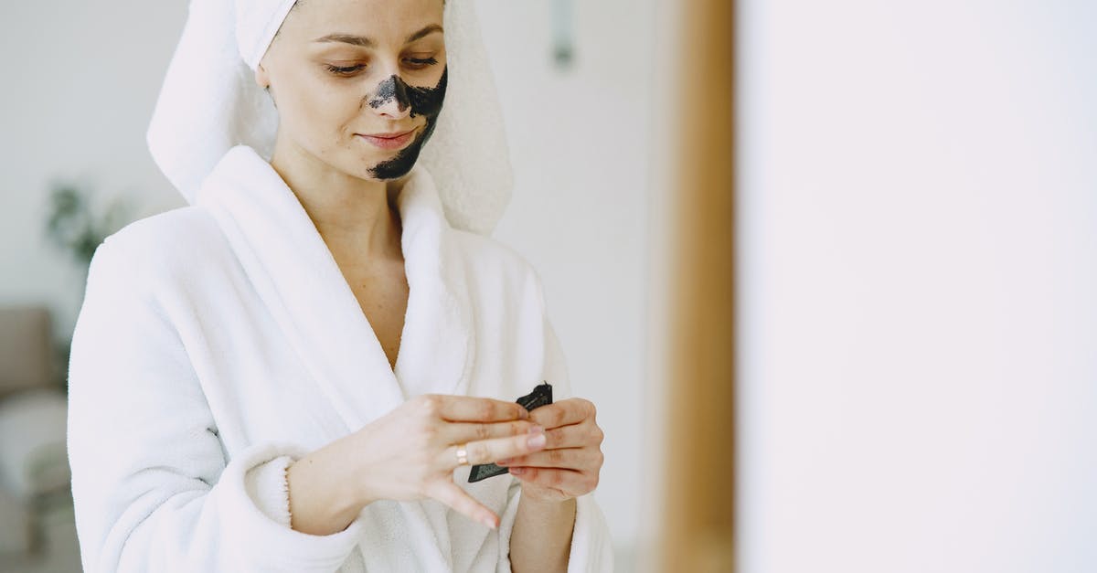 What is the use of all these towels? - Crop satisfied woman applying mask on face at home