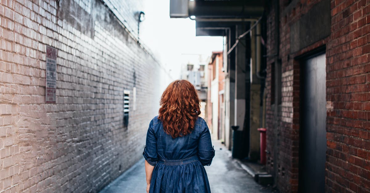 What is the youngest age a minor is allowed to travel alone internationally? - Anonymous stylish woman standing on street in old city district What is the youngest age a minor is allowed to travel alone internationally? - Anonymous stylish woman standing on street in old city district
