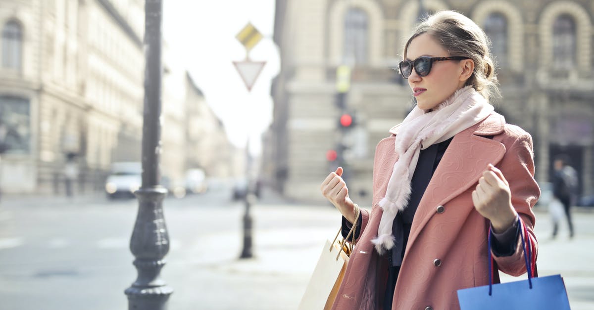 What is this extra item that came with my travel bag? - Woman in Pink Coat Holding Shopping Bags