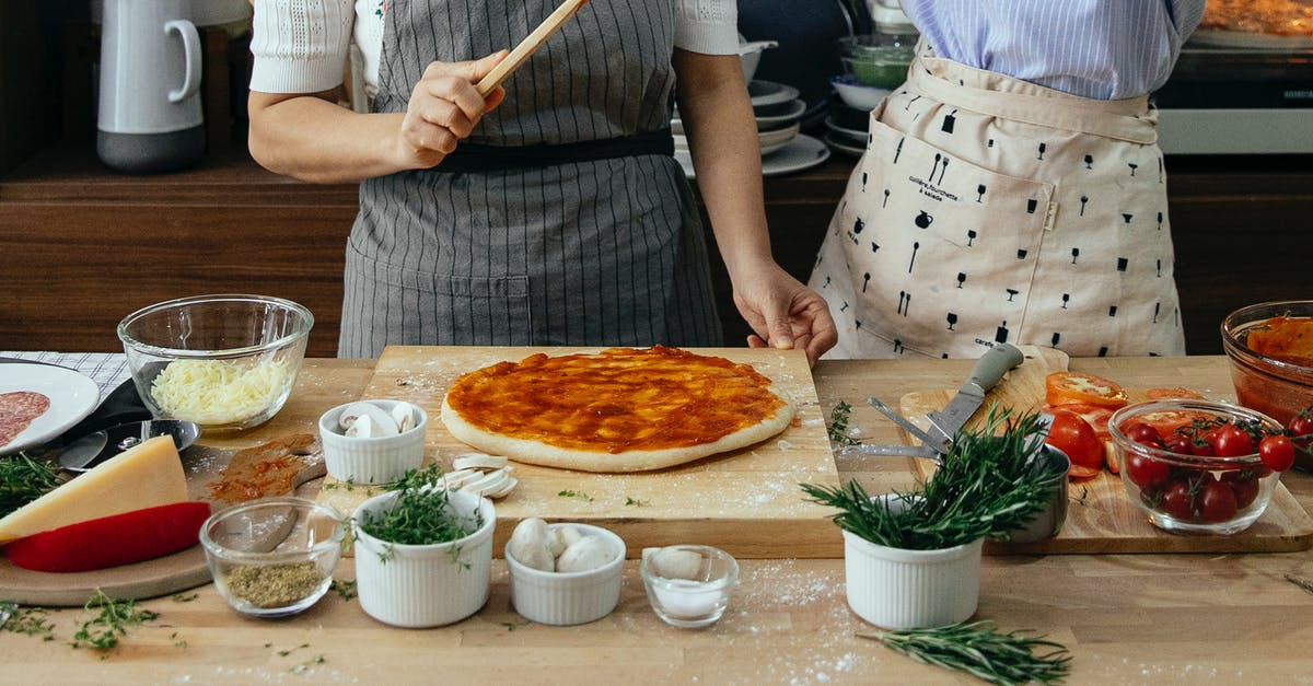 What is this sweet, thick, soy-sauce-like condiment in China? - Crop anonymous female cooks at table with tomato salsa on raw dough near assorted ingredients for pizza in house