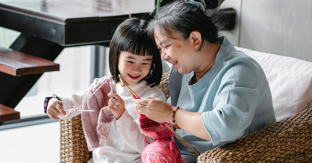 What kind of clothes should I use at Egypt and Jordan during the daylight [closed] - Cheerful senior Asian woman sitting in armchair and helping curious little granddaughter  to knit warm clothes with yarn in daylight