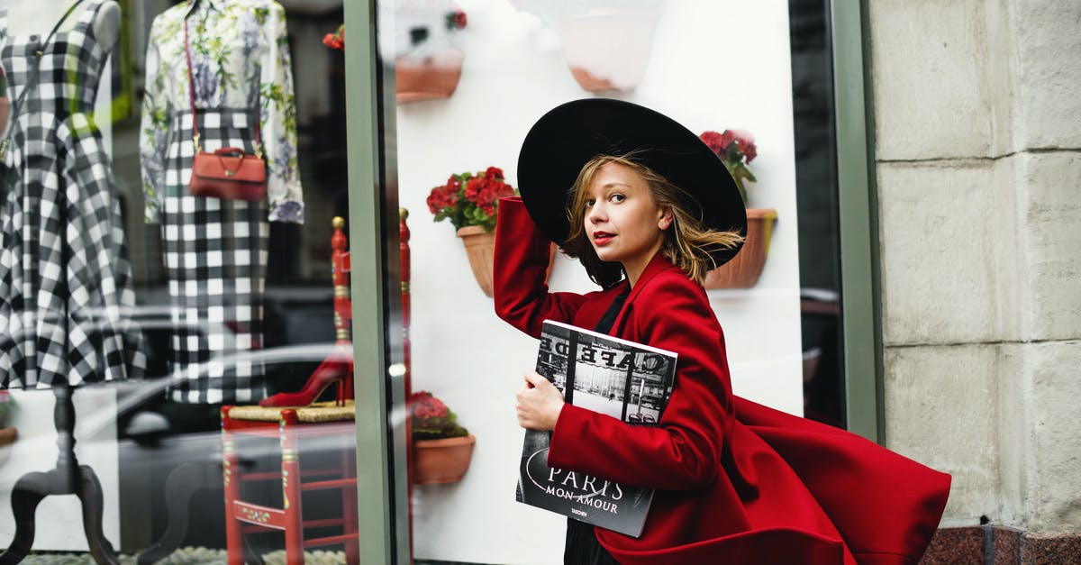 What kind of hat to wear for business in India? - Woman in Red Coat Holding Book