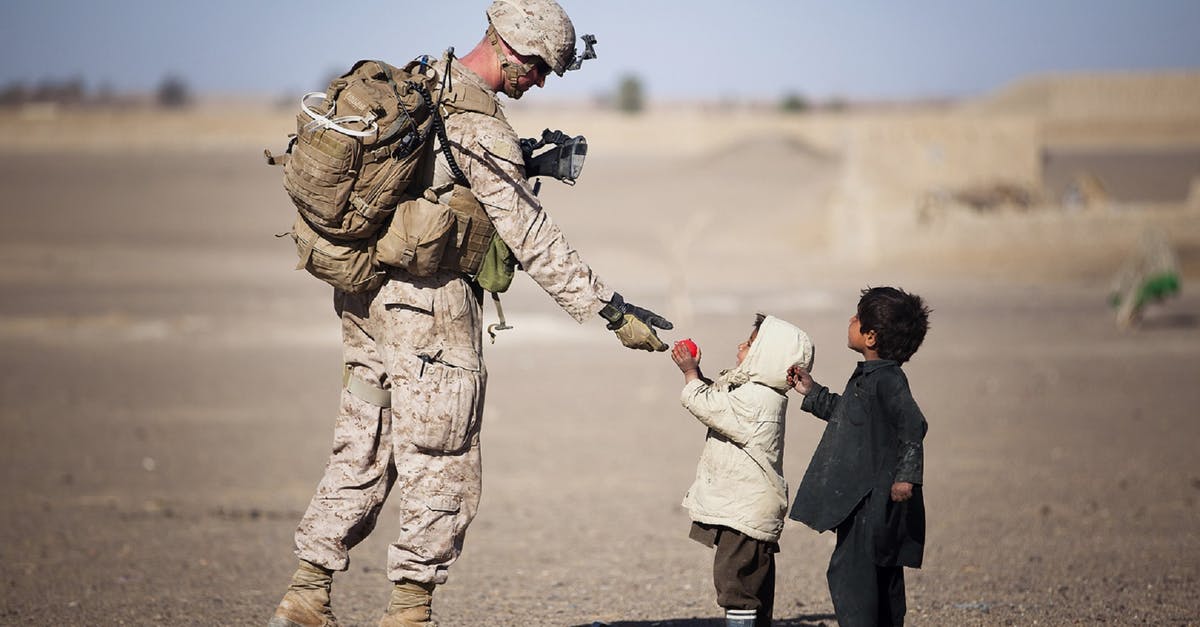 What kind of proof of residency is accepted by Disneyland? - Soldier Giving Red Fruit on 2 Children during Daytime