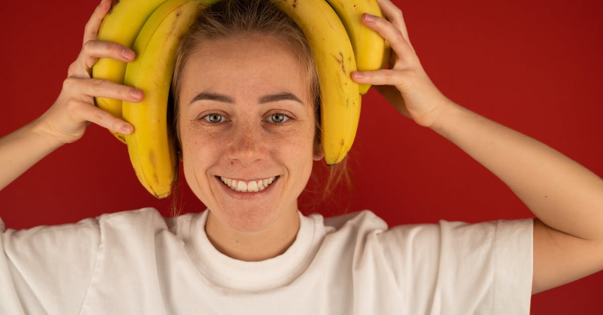 What kind of questions should I be asking about tropical destinations? - Smiling woman with bunch of fresh bananas on head