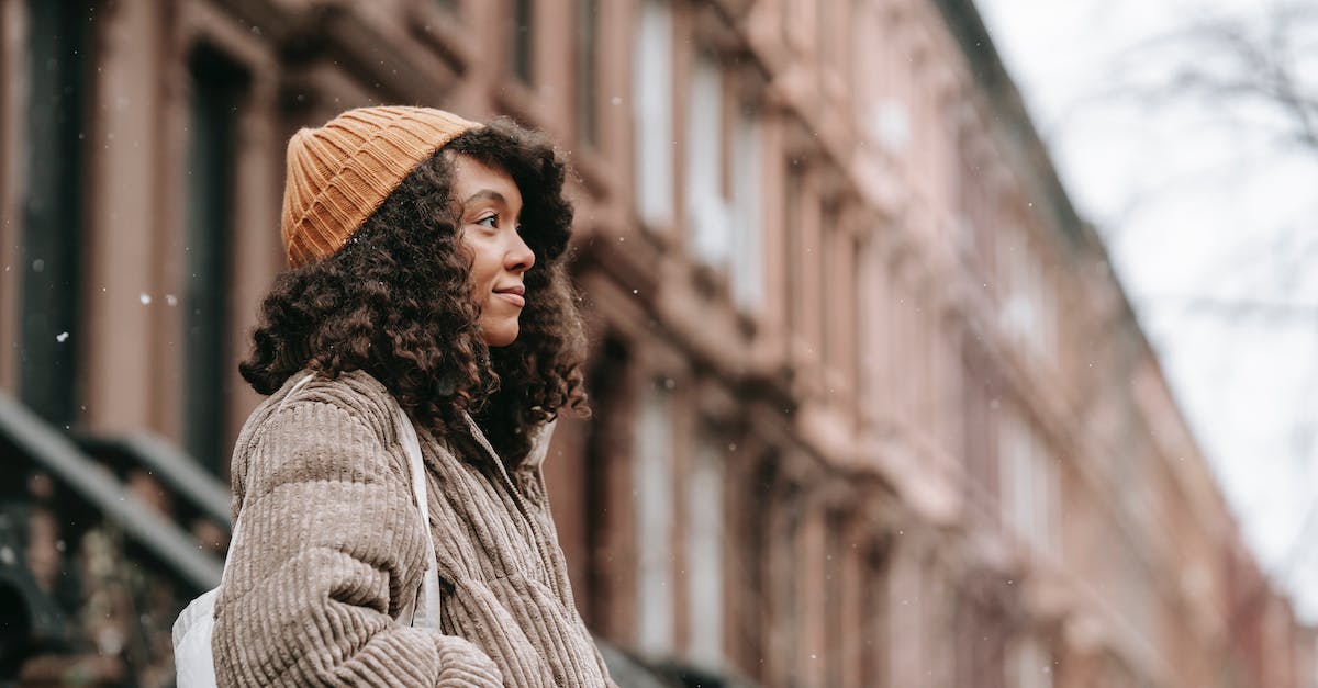 What kind of weather can I expect in Maui in October? - Contemplative black woman on street in snowfall