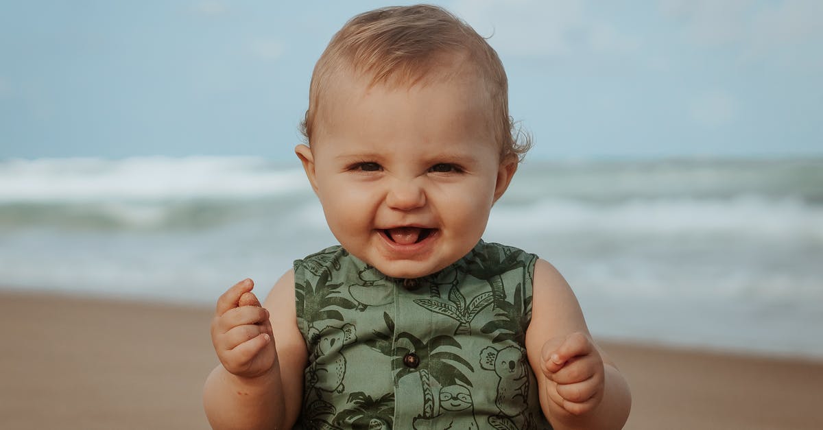 What kind of weather to expect in Budapest in late March/early April? - Cheerful baby on sandy sea shore in stormy weather