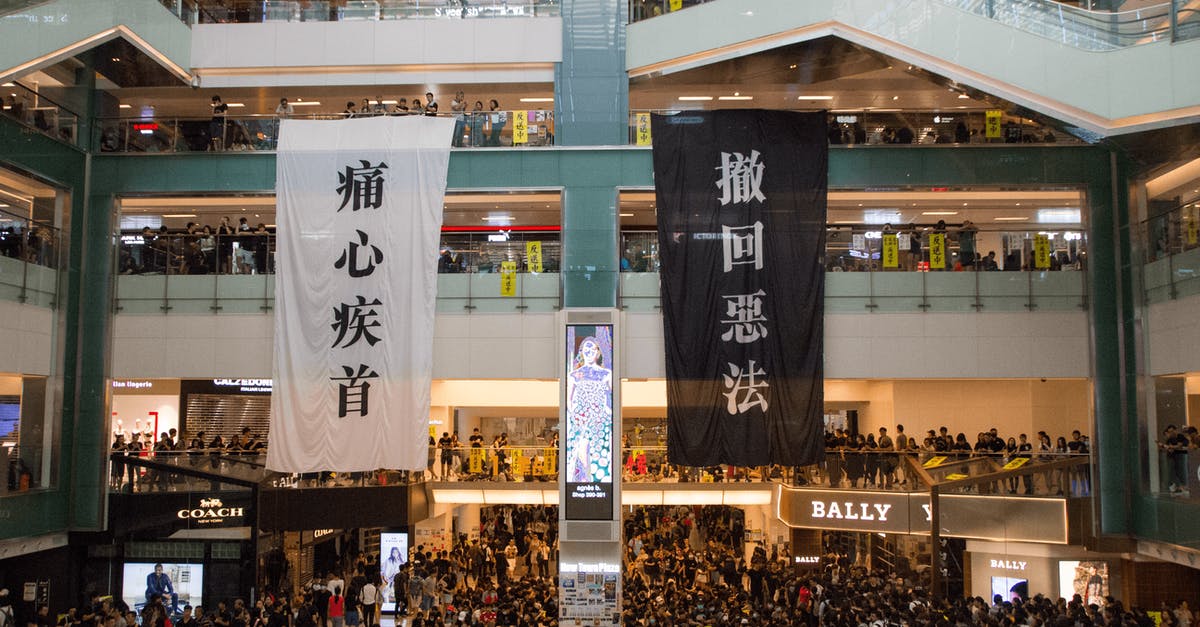 What luggage features prevent theft? - Shopping centre with hanging protestant banners crowded with people on meeting