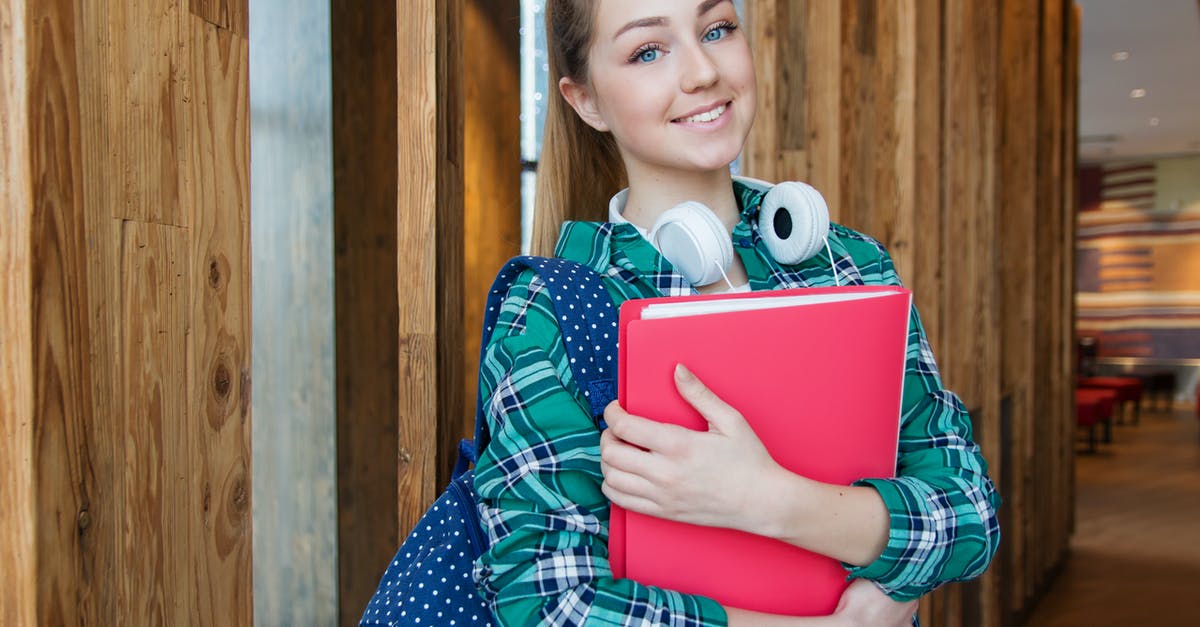 What makes a backpack a women's backpack? - Woman Standing in Hallway While Holding Book