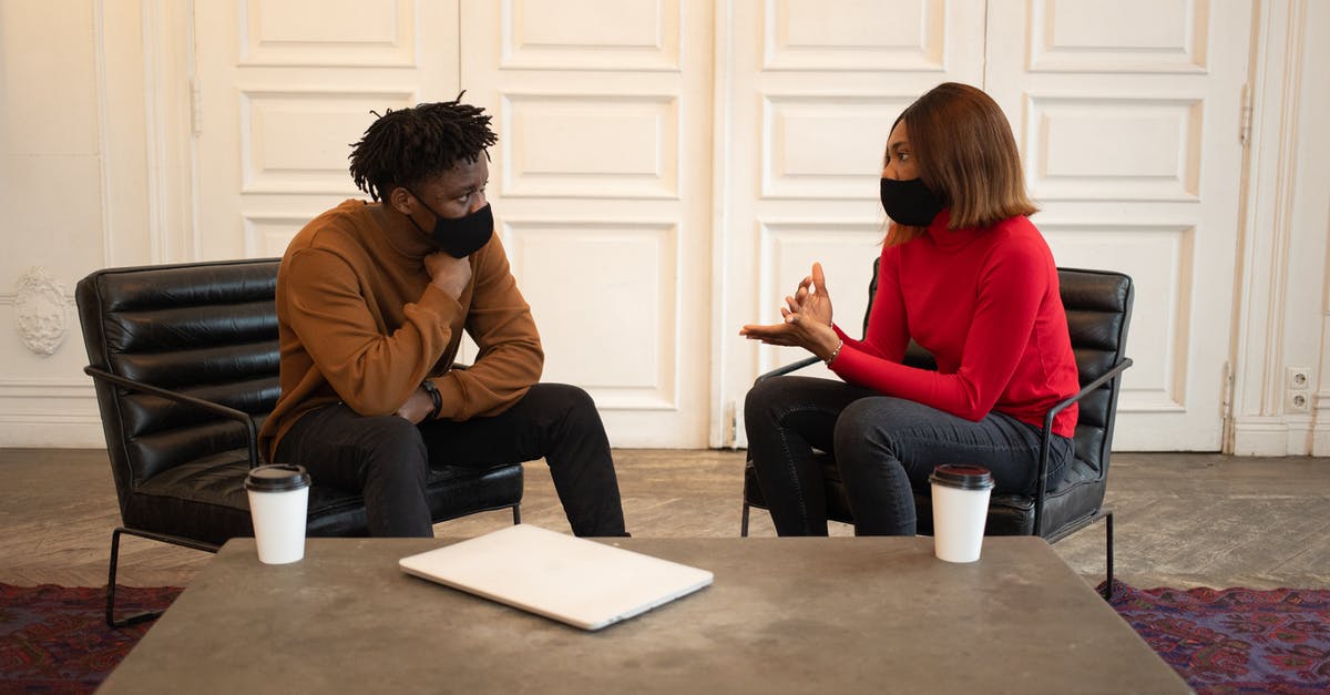 What measures are taken to prevent bombs being smuggled onto planes via insider jobs? - Focused African American colleagues in protective masks looking at each other while having conversation about work at table with laptop and paper cups of takeaway coffee What measures are taken to prevent bombs being smuggled onto planes via insider jobs? - Focused African American colleagues in protective masks looking at each other while having conversation about work at table with laptop and paper cups of takeaway coffee