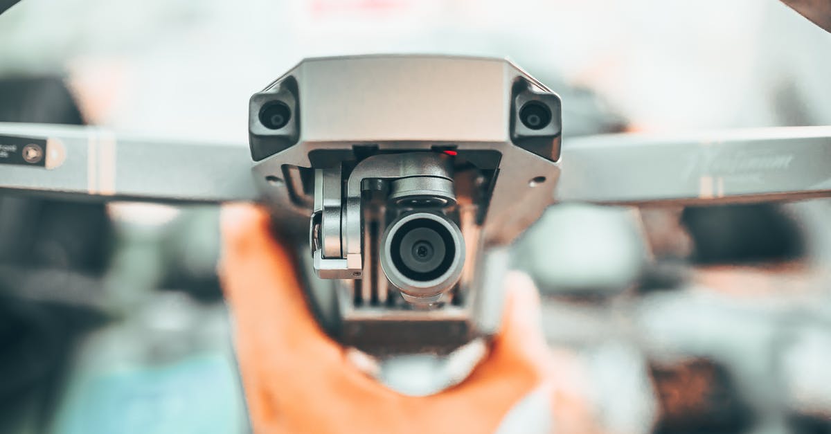 What powerbank can I use on the flight? - Crop unrecognizable person holding contemporary drone against blurred interior and demonstrating powerful camera