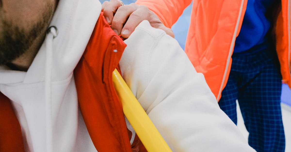 What practices can help me hitchhike safely? [closed] - Closeup of hand of trainer on shoulder of male member of sport team while supporting sportsmen in competition