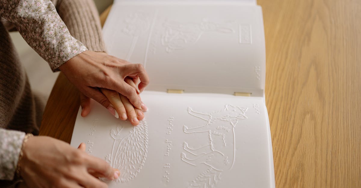 What proof of disability is accepted in France? - A Person Assisting a Child Read a Braille Book