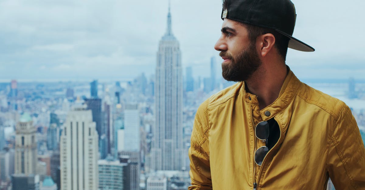 What publicly accessible tall buildings are good for views & photography in Manhattan? - Portrait Photo of Man in Yellow Zip-up Jacket Near Empire State Building