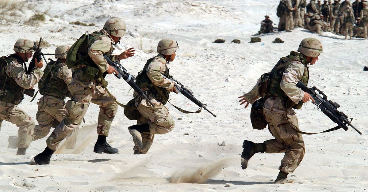 What self-defense weapons are legal in London? - 5 Soldiers Holding Rifle Running on White Sand during Daytime