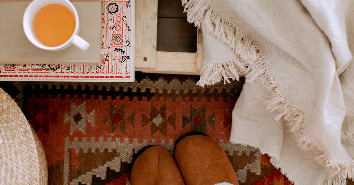 What shoes required for simple trekking in Georgia? - From above of cozy bedroom interior with white plaid, brown warm slippers on carpet, wicker basket and cup of tea on tray