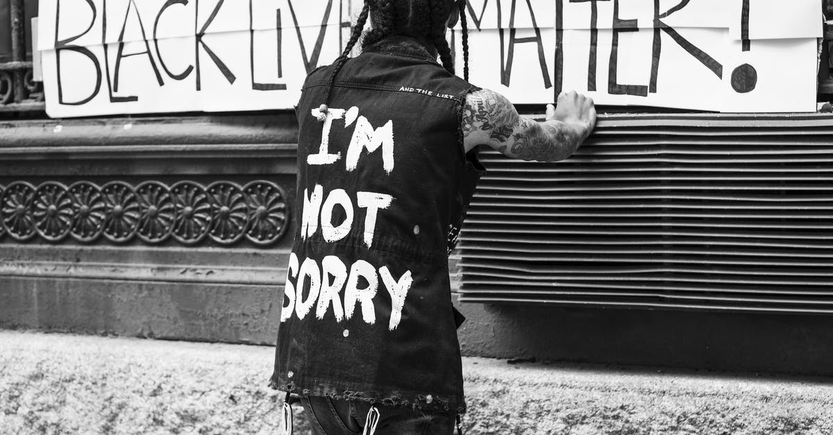 What should I do if I get caught by corrupt police in Ukraine but never want to pay? - Back view of unrecognizable tattooed guy standing on street in front of banner with Black Lives Matter inscription What should I do if I get caught by corrupt police in Ukraine but never want to pay? - Back view of unrecognizable tattooed guy standing on street in front of banner with Black Lives Matter inscription
