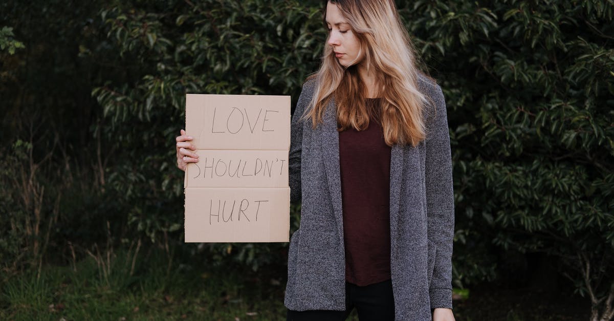 What should I do to avoid ear pain when flying? - Female demonstrating cardboard with words against abuse