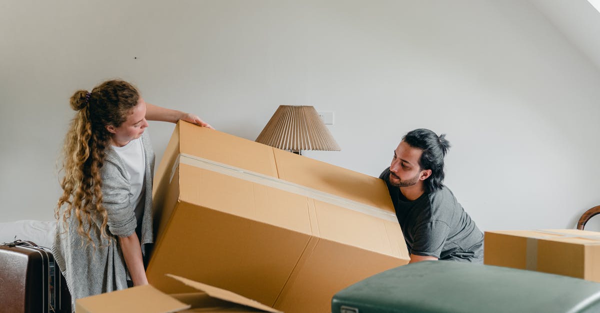 What technique is best for moving two large (23kg) suitcases, reasonably short distances (<1km)? - Man and woman carrying carton box What technique is best for moving two large (23kg) suitcases, reasonably short distances (<1km)? - Man and woman carrying carton box