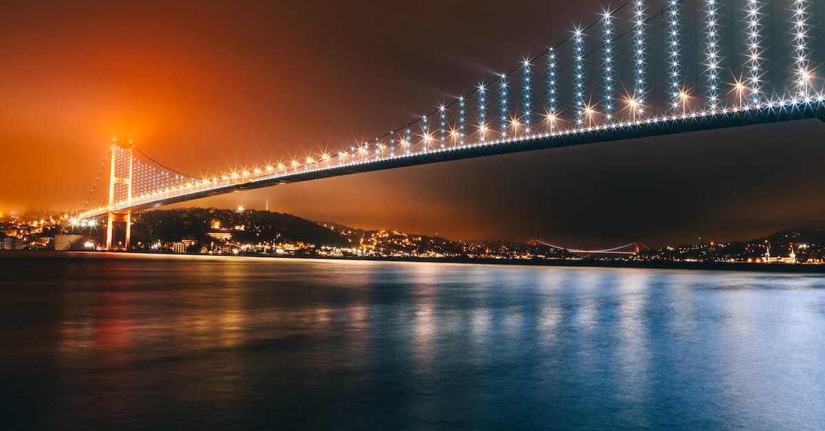 What time do the city buses start running in Istanbul? - Bridge over Water during Night Time